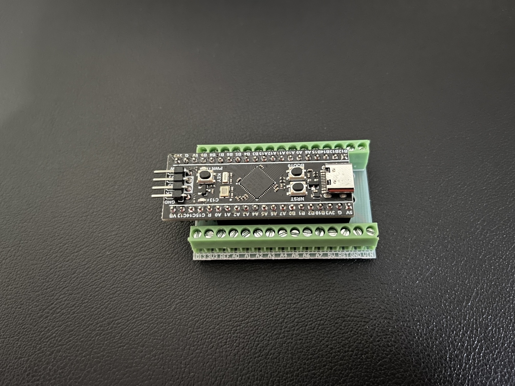 Photo of a microcontroller inserted into a breakout board with terminal blocks.